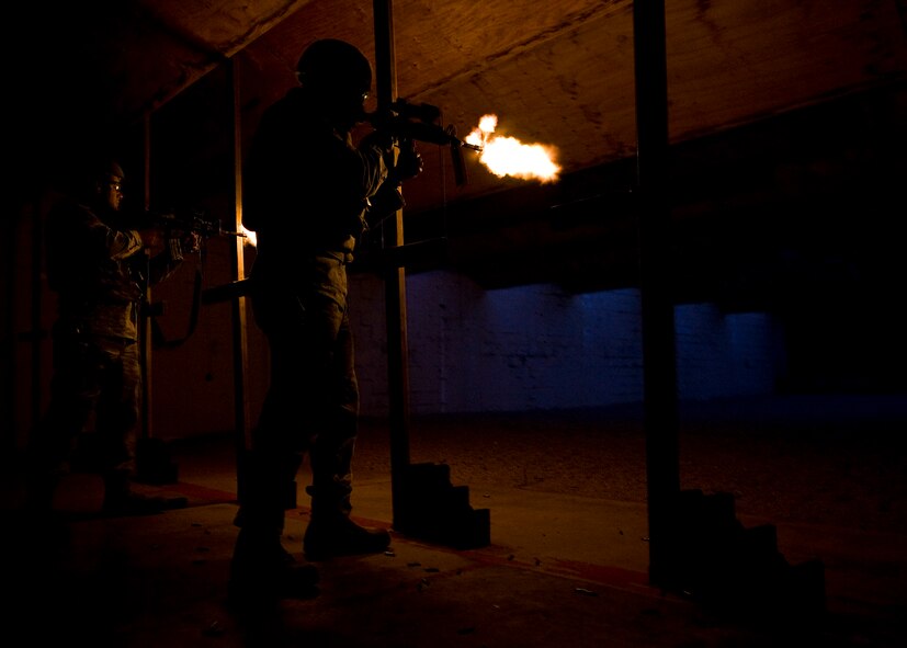 Senior Airman Nicholas Navarro, left, and Senior Airman Alexi Patterson, right, 7th Security Forces Squadron, fire their M-4 Carbines during night-fire training July 19, 2012 at Dyess Air Force Base, Texas. Airmen fired 70 rounds from an M-4 Carbine mounted with a PVS-14 in front of a red dot sight. The scope collects small amounts of light and amplifies it, allowing the shooter to see down range in low-light situations. The targets were 25 feet away, but distances are simulated between 70 and 300 meters. (U.S. Air Force photo by Airman 1st Class Damon Kasberg/Released)