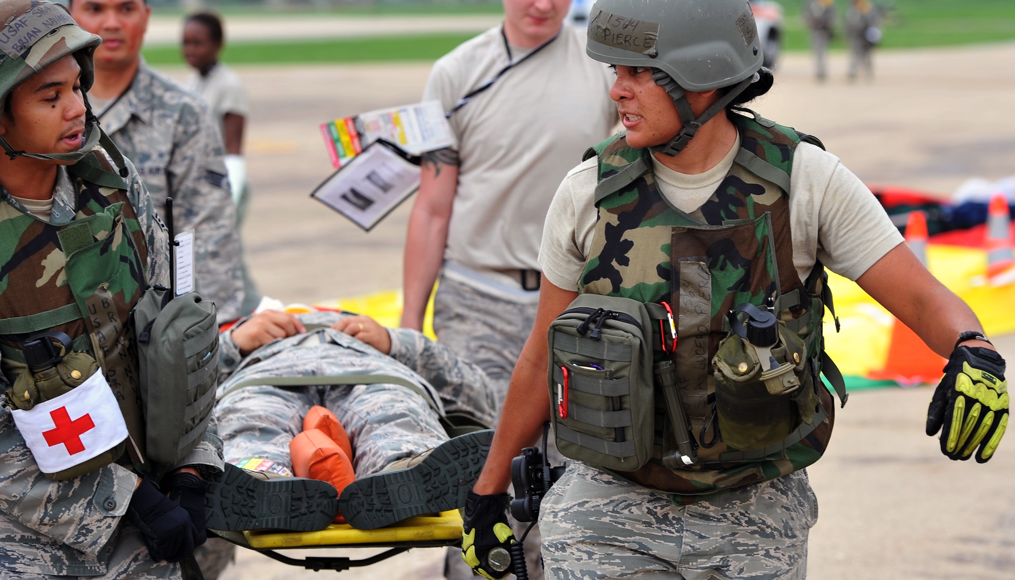 Senior Airman Lucero Pierce (right), 51st Civil Engineer Squadron, and Senior Airman Brian Navarrete, 51st Aerospace Medicine Squadron, lead a four-person litter move to an ambulance during operational readiness exercise Beverly Midnight 12-03, July 23, 2012. This scenario tested the readiness of Osan’s first responders as well as their abilities to work together to accomplish the mission during the heightened state of readiness. Airmen are evaluated every quarter on their skills to survive and operate in a wartime environment, as well as defend the base, execute combat operations and receive follow-on forces. (U.S. Air Force photo/Staff Sgt. Craig Cisek)