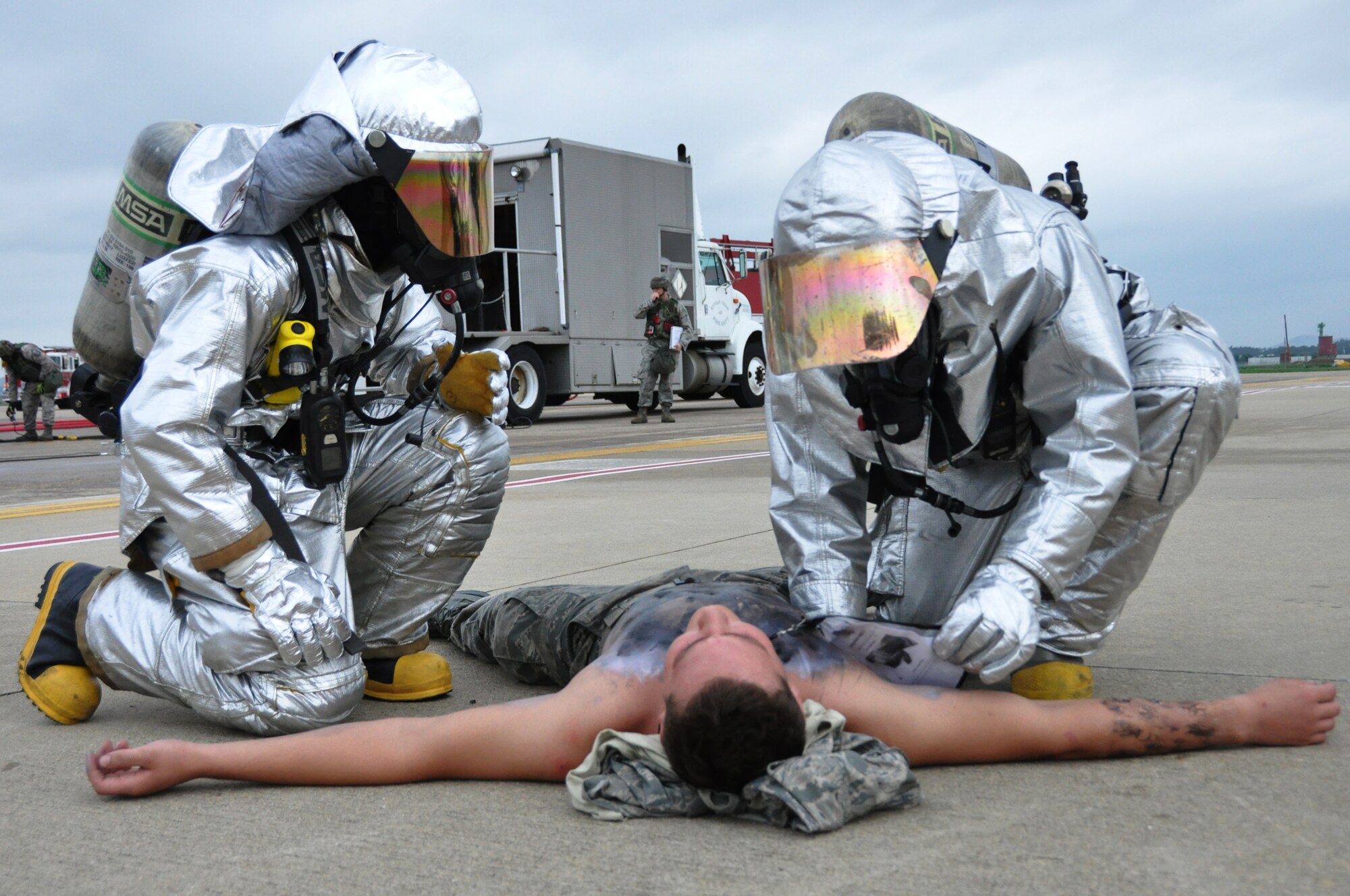 Firefighters from the 51st Civil Engineer Squadron access injuries during a simulated aircraft crash at Osan Air Base, Republic of Korea during operational readiness exercise Beverly Midnight 12-03, July 23, 2012. Throughout the week, Osan Mustangs demonstrate the ability to operate in a chemical environment as well as administer self-aid and buddy-care during a wartime environment. BM 12-03 is the first ORE since the Consolidated Unit Inspection in late April. (U.S. Air Force photo/Senior Airman Michael Battles) 