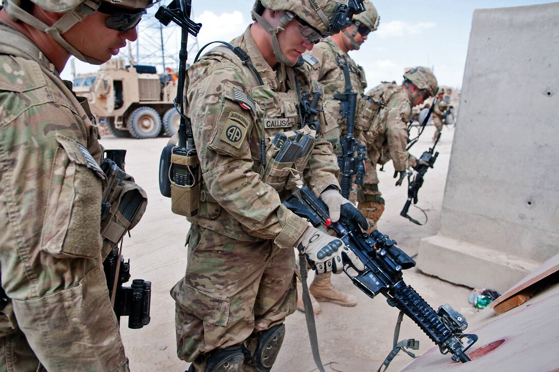 U.S. Army 2nd Lt. Jason Callison, center, clears his M4 carbine with the assistance of another soldier who inspects the chamber on Forward Operating Base Arian, in Afghanistan's Ghazni province, July 16, 2012. Callison, a platoon leader, is assigned to the 82nd Airborne Division's 2nd Battalion, 504th Parachute Infantry Regiment, 1st Brigade Combat Team.