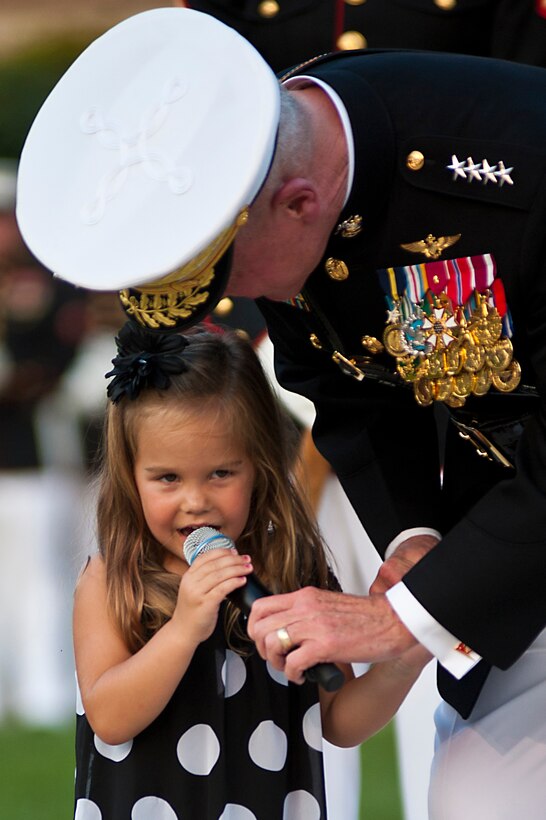 Gen. James F. Amos, commandant of the Marine Corps, hands the microphone to the granddaughter of Lt. Gen. Dennis Hejlik, commanding general of Marine Forces Europe and Marine Corps Forces Command, so she can say a few words during Hejlik's retirement ceremony at Marine Barracks Washington July 23. Hejlik was awarded the Distinguished Service Medal during the ceremony for 44 years of dedicated service to Corps and country.