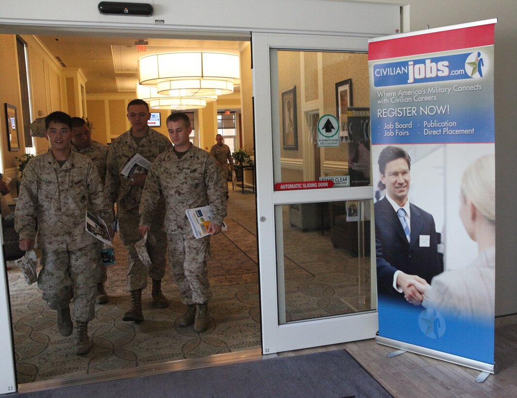 A group of Marines leave with informational handouts from employers during the Career Exposition sponsored by CareerJobs.com, hosted at Marston Pavilion aboard Marine Corps Base Camp Lejeune July 19. More than a dozen companies, departments and organizations spoke to service members, military spouses and base patrons at the function.  