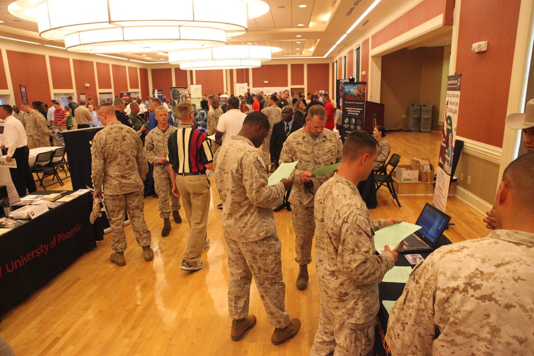 Base patrons speak with employers during the Career Exposition sponsored by CareerJobs.com, hosted at Marston Pavilion aboard Marine Corps Base Camp Lejeune July 19. More than a dozen companies, departments and organizations spoke to service members, military spouses and base patrons at the function.  