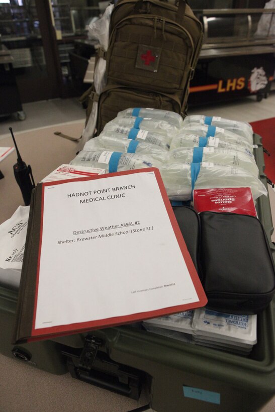 Corpsmen with the Hadnot Point Branch Medical Clinic display medical supply kits at Lejeune High School as part of the base destructive weather exercise hosted aboard Marine Corps Base Camp Lejeune July 18. The teams cleared rooms in the shelters to stage supplies such as cots and water containers. 