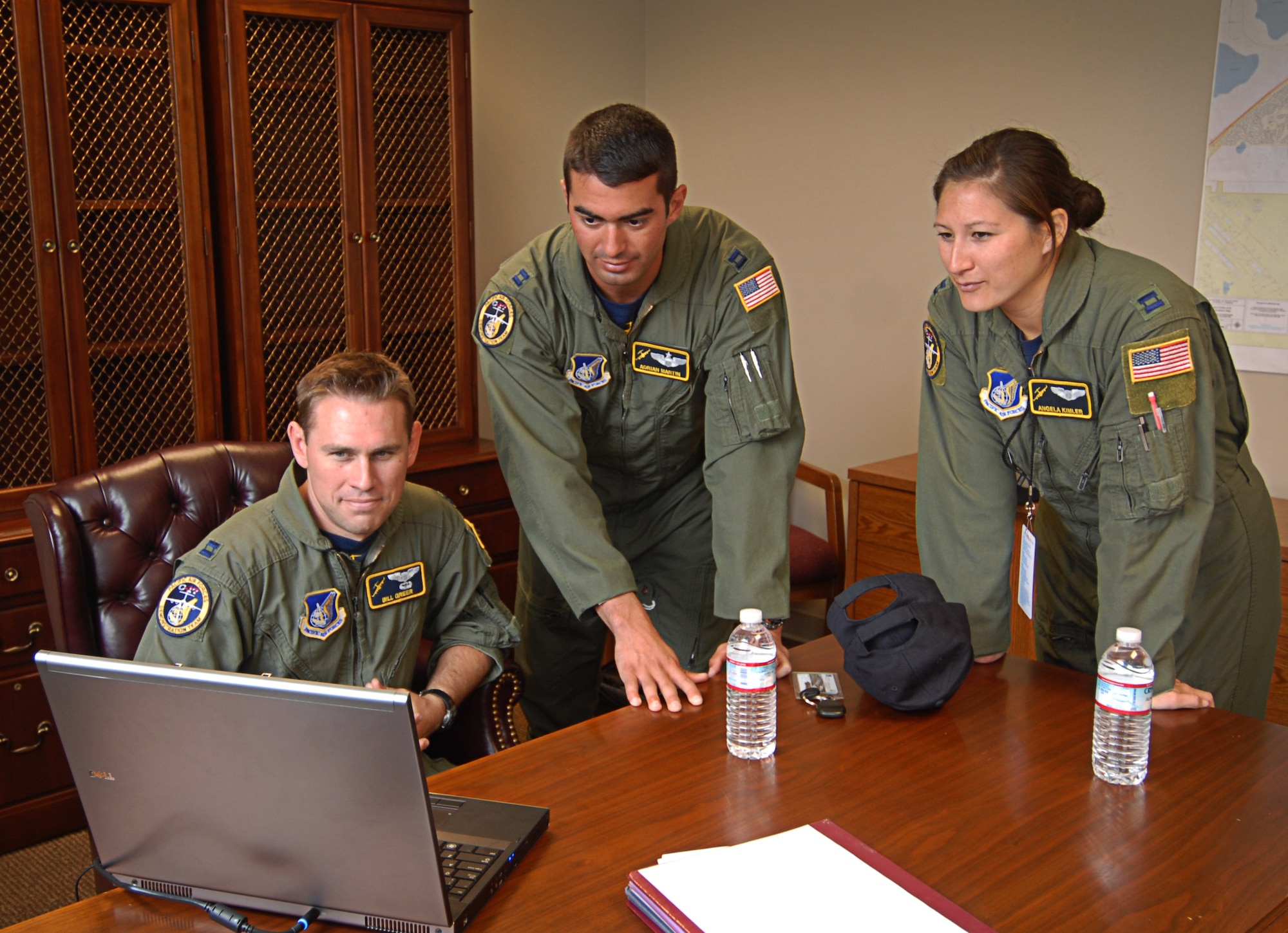 Capt. Bill Greer (seated), Capt. Adrian Martin and Capt. Angela Kimler, members of the Pacific Air Forces C-17 Aerial Demonstration Team, critique the video of the team's performance during debrief at the Joint Base Lewis-McChord Air Expo 2012 at McChord Field, Washington July 22. The JBLM Air Expo 2012 featured 20 aerial performers and over 40 static aircraft displays. (U.S. Air Force photo by 2nd Lt. Jessica Colby) 