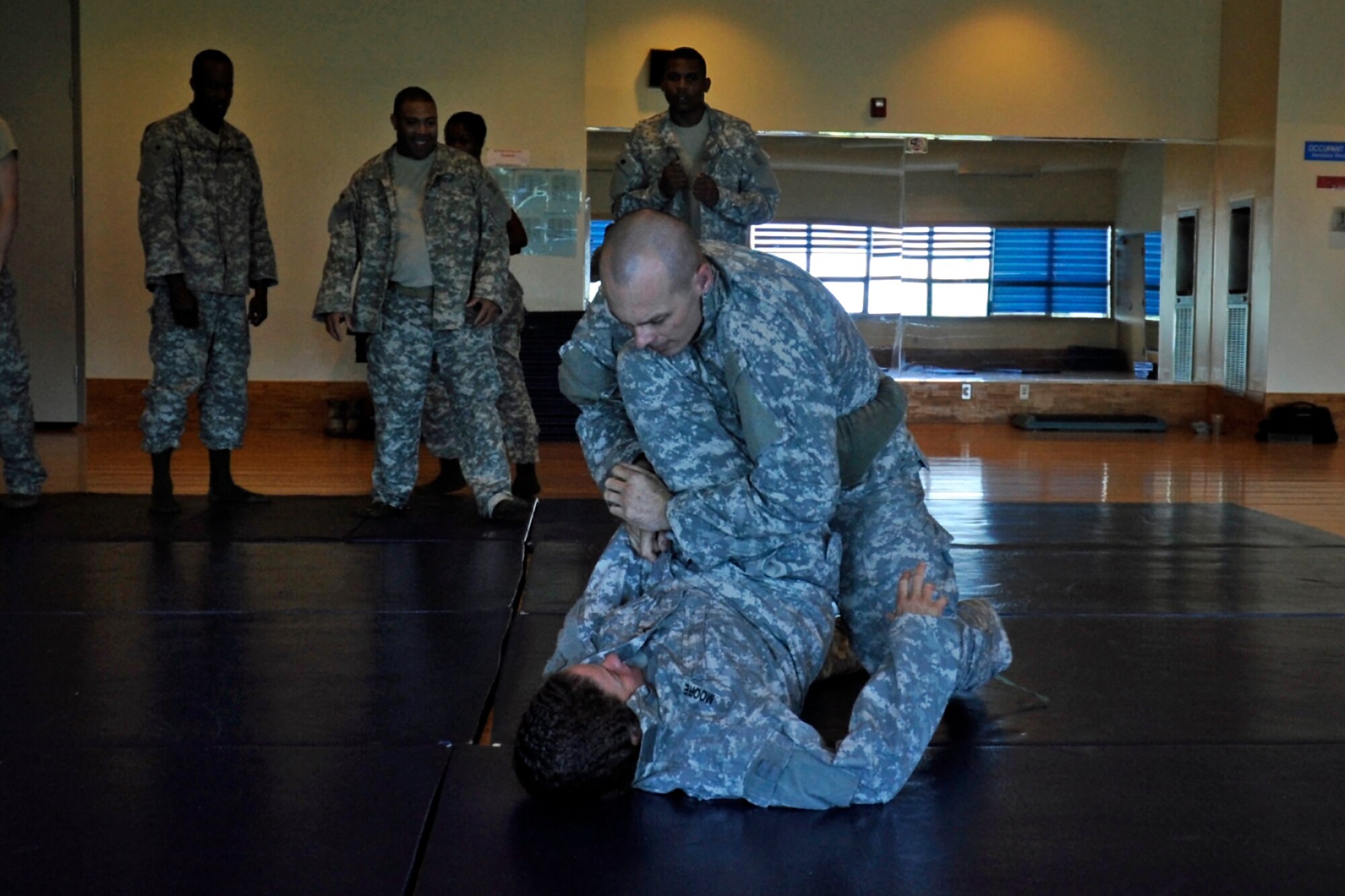 Pfc. Connie Moore, bottom, Alpha Battery, 2nd Battalion of the 1st Air Defense Artillery, and Pvt. Larry Harper, AB 2-1 ADA, participate in a “battle royale” challenge, July 24, 2012, at the Wolf Pack Fitness Center. The battle royale, sometimes called “Last Solider Out,” gave participants a chance to use what they learned during the class. (U.S. Air Force photo/Senior Airman Jessica Hines)