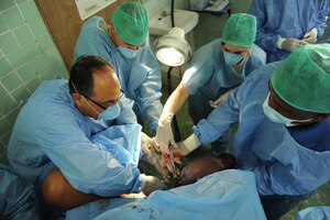 (Left to right) Dr. Guillermo Saenz, Army Capt. Curtis Million and Air Force Staff Sgt. Adrianna Bascochea-Gibbs of JTF-Bravo and a doctor from the Panama Ministry of Health hold a newborn, clamp and cut the umbillical cord immediately after the delivery of a baby boy on the final day of the Panama MEDRETE, July 19. Doctors delivered three babies, two boys and one girl, during the four-day exercise. Two of the babies were named after JTF-Bravo dentists. (Official photo by Tech. Sgt. Brannen Parrish)