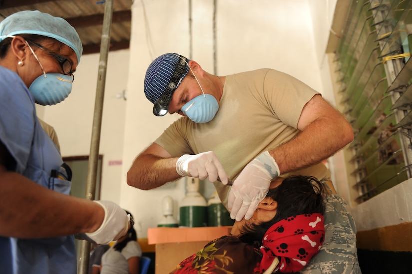 Air Force Maj. Brent Waldman, dentist, JTF-Bravo Medical Element, extracts a tooth from a Guna woman on the Island of Carti, during a Medical Readiness Training Exercise off the northeastern coast of Panama, July 17. Waldman dentists from the JTF-Bravo and the Panama Ministry of Health extracted thousands of teeth during the four day exercise. The Guna people so appreciated his work that a Guna woman named her son after him. (Official photo by Tech. Sgt. Brannen Parrish)