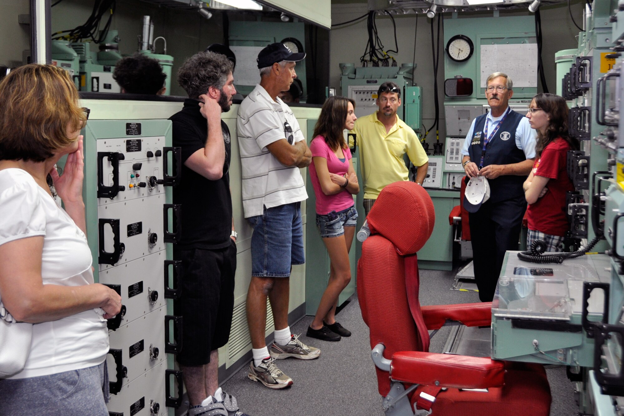 Ron McElland, a volunteer docent at the Peterson Air and Space Museum, talks to visitors about one of the museum’s many displays. (U.S. Air Force photo/Dan Santistevan)