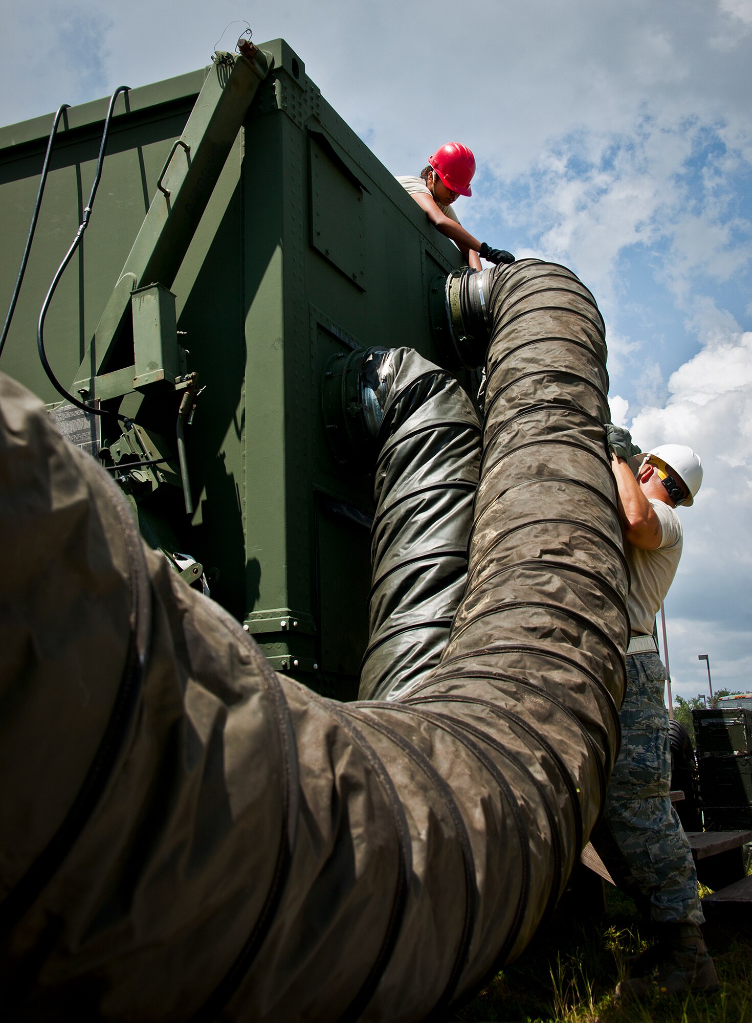 Senior Airman Brandi Phillips, a 728th Air Control Squadron digital maintenance technician, installs an environmental control unit duct onto a mobile operations module during a deployment readiness Exercise called Bison Fury July 24 at Eglin Air Force Base, Fla.  This exercise marks the last large-scale exercise for the squadron, which is scheduled to be deactivated in 2013.  (U.S. Air Force photo/Samuel King Jr.)