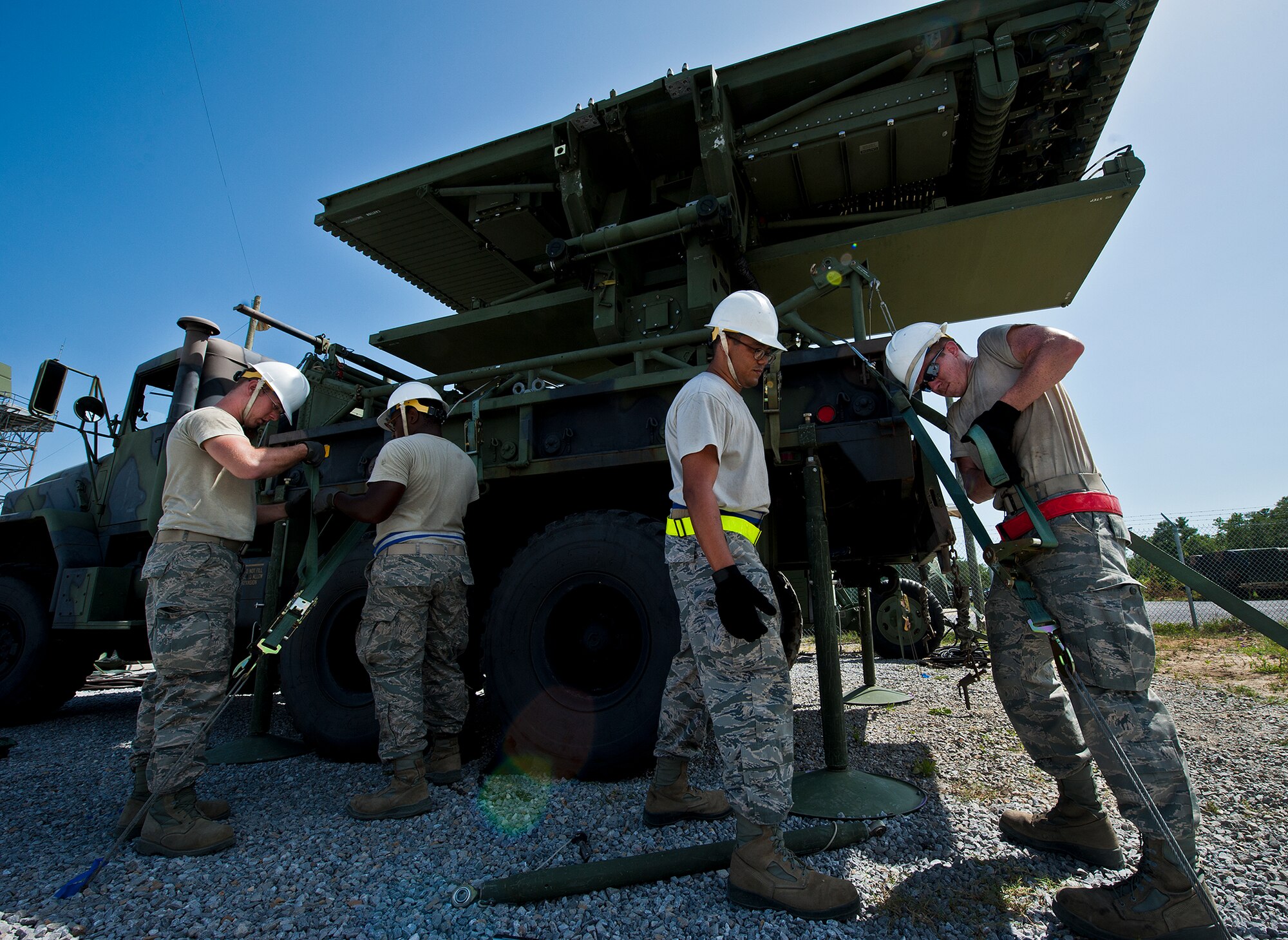 Airmen from the 728th Air Control Squadron secure tie-down straps for a TPS-75 radar set antenna in support of a deployment readiness exercise called Bison Fury July 24 at Eglin Air Force Base, Fla.  This exercise marks the last large-scale exercise for the squadron, which is scheduled to be deactivated in 2013.  (U.S. Air Force photo/Samuel King Jr.)