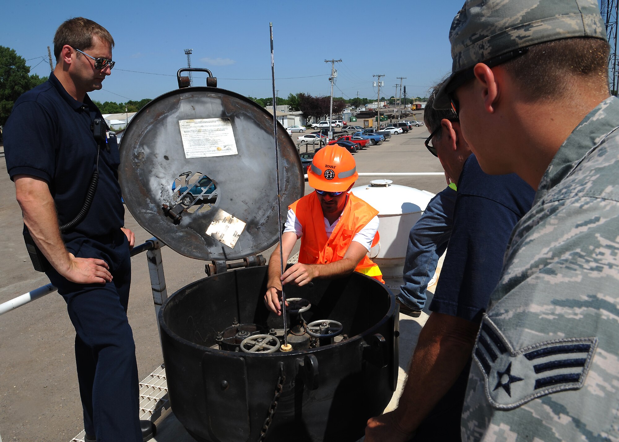 Andrew Bacinl, of the Burlington Northern Santa Fe Railroad, describes a tank car valve system during an emergency response training session on July 23, 2012, in Grand Forks, N.D.  Members of the Grand Forks Air Force Base Fire Department and other local agencies took part in the training which simulated a hazardous material leak.  (U.S. Air Force photo by Airman 1st Class Xavier Navarro)