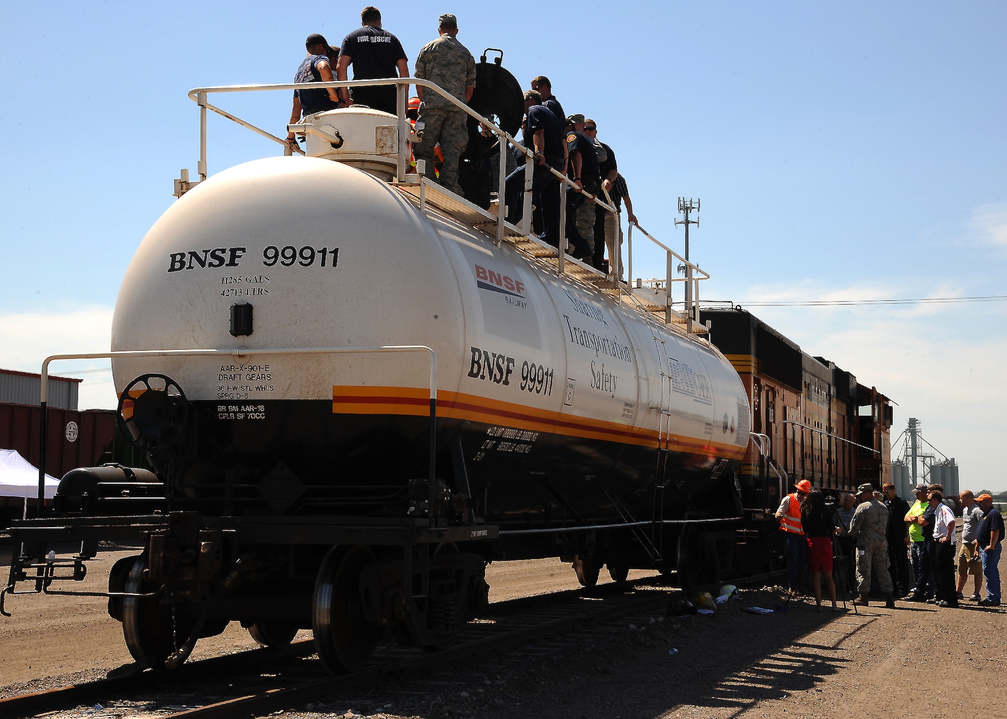 Members of local emergency response agencies discuss a tank car valve system during an emergency response training session on July 23, 2012, in Grand Forks, N.D.  Members of the Grand Forks Air Force Base Fire Department participated in the training which simulated a hazardous material leak.  (U.S. Air Force photo by Airman 1st Class Xavier Navarro)