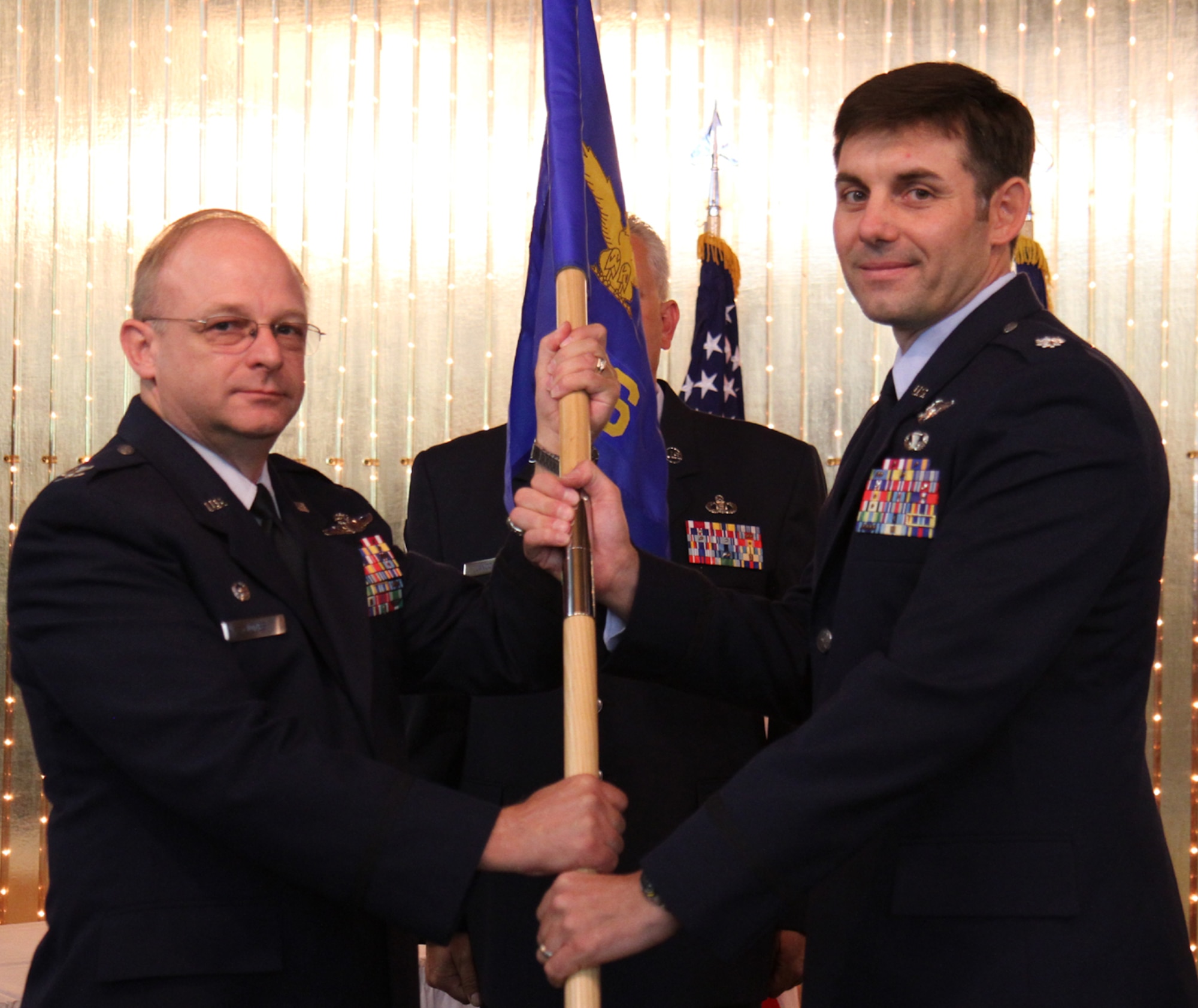 Lt. Col. Christopher Lay, right, accepts the Operations Support Squadron guidon from Operations Group Commander, Col. Kurt Jones. Lay become the new OSS commander during a ceremony at Peterson Air Force Base Club July 14, 2012. (U.S. Air Force photo/Maj. Stephen Kifer) 