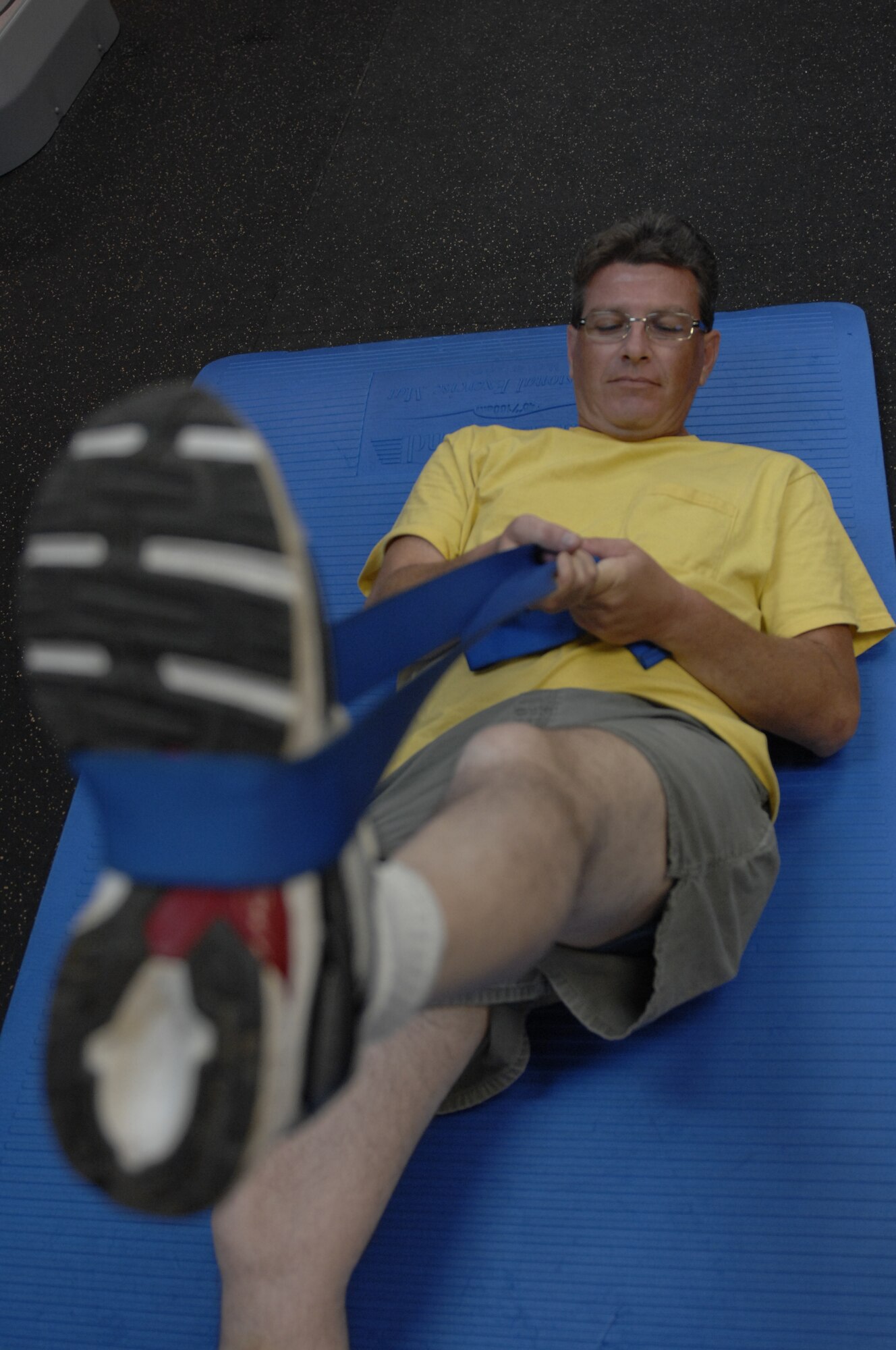 Tech. Sgt. John Cates, 20th Equipment Maintenance Squadron armament support member and a native of Rockwood, Tenn., uses a blue band to stretch his leg and thigh during a physical therapy session at Shaw Air Force Base, S.C., July 23, 2012. According to Maj. Justin Martin, 20th Medical Group physical therapy flight commander and a native of Fairfield, Idaho, physical therapy restores long term function and prevents future disabilities. Therapy could include therapeutic exercises, functional training, deep soft tissue massage, and physical modalities such as electrotherapy and ultrasound which are pain-controlling treatments. (U.S. Air Force photo by Airman 1st Class Krystal Jeffers/Released)
