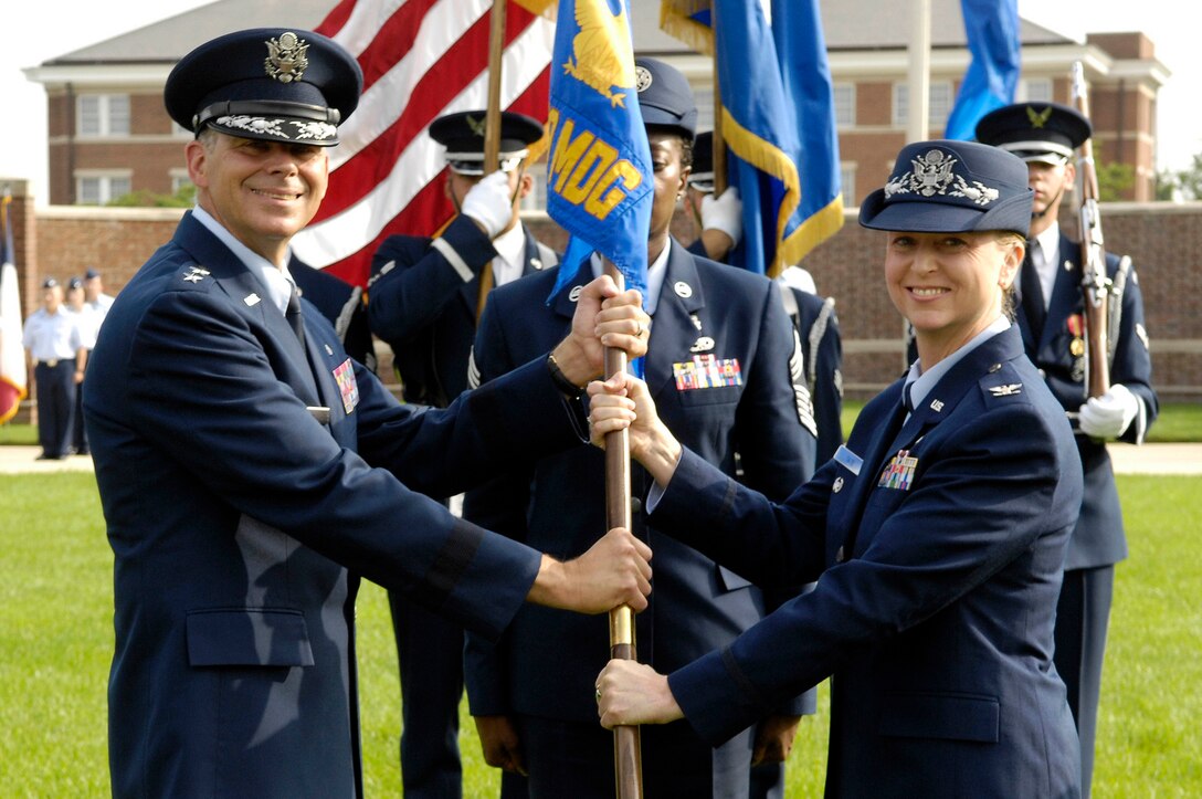 Maj. Gen. Gerard Caron, 79th Medical Wing commander, passes the 579th Medical Group guidon to Incoming Commander Col. Kathryn Tate during a Change of Command Ceremony on the U.S. Air Force Ceremonial Lawn, July 23, at Joint Base Anacostia-Bolling. Tate assumed command from outgoing commander Col. Roseanne Warner. (U.S. Air Force photos by Senior Airman Steele C. G. Britton
