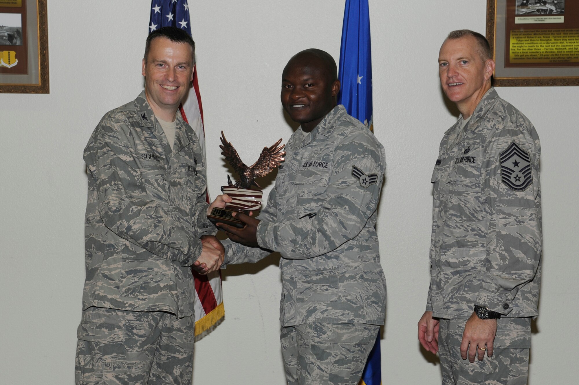 Col. Thomas Schmidt, 17th Training Wing Vice Commander, and Chief Master Sgt. Scott Lumpkin, 17th TRW Command Chief, present the Team Goodfellow Junior Enlisted of the Quarter to Senior Airman Blaise Muluh, 17th Medical Operations Squadron, during the wing quarterly awards ceremony July 24. (U.S. Air Force photo by Staff Sgt. Austin Knox)