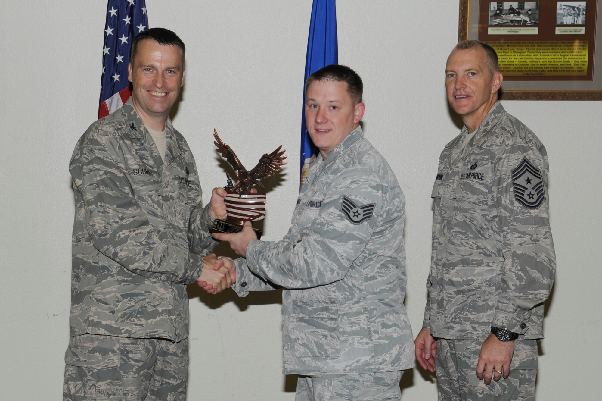 Col. Thomas Schmidt, 17th Training Wing Vice Commander, and Chief Master Sgt. Scott Lumpkin, 17th TRW Command Chief, present the Team Goodfellow Volunteer of the Quarter to Staff Sgt. Jeremy Smith, 17th Security Forces Squadron, during the wing quarterly awards ceremony July 24. (U.S. Air Force photo by Staff Sgt. Austin Knox)