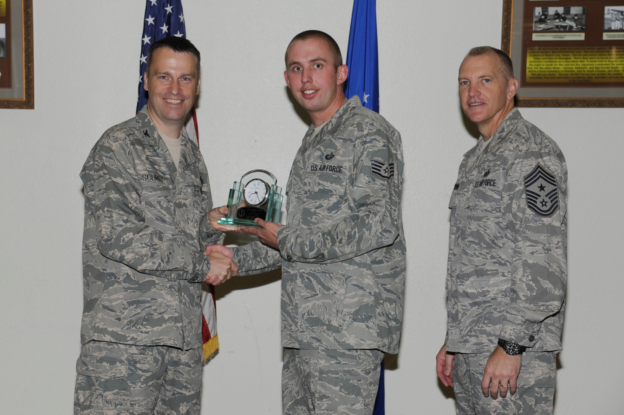 Col. Thomas Schmidt, 17th Training Wing Vice Vommander, and Chief Master Sgt. Scott Lumpkin, 17th TRW Command Chief, present the 17th Training Wing NCO of the Quarter to Staff Sgt. James Burns, 17th Force Support Squadron, during the wing quarterly awards ceremony July 24. (U.S. Air Force photo by Staff Sgt. Austin Knox)