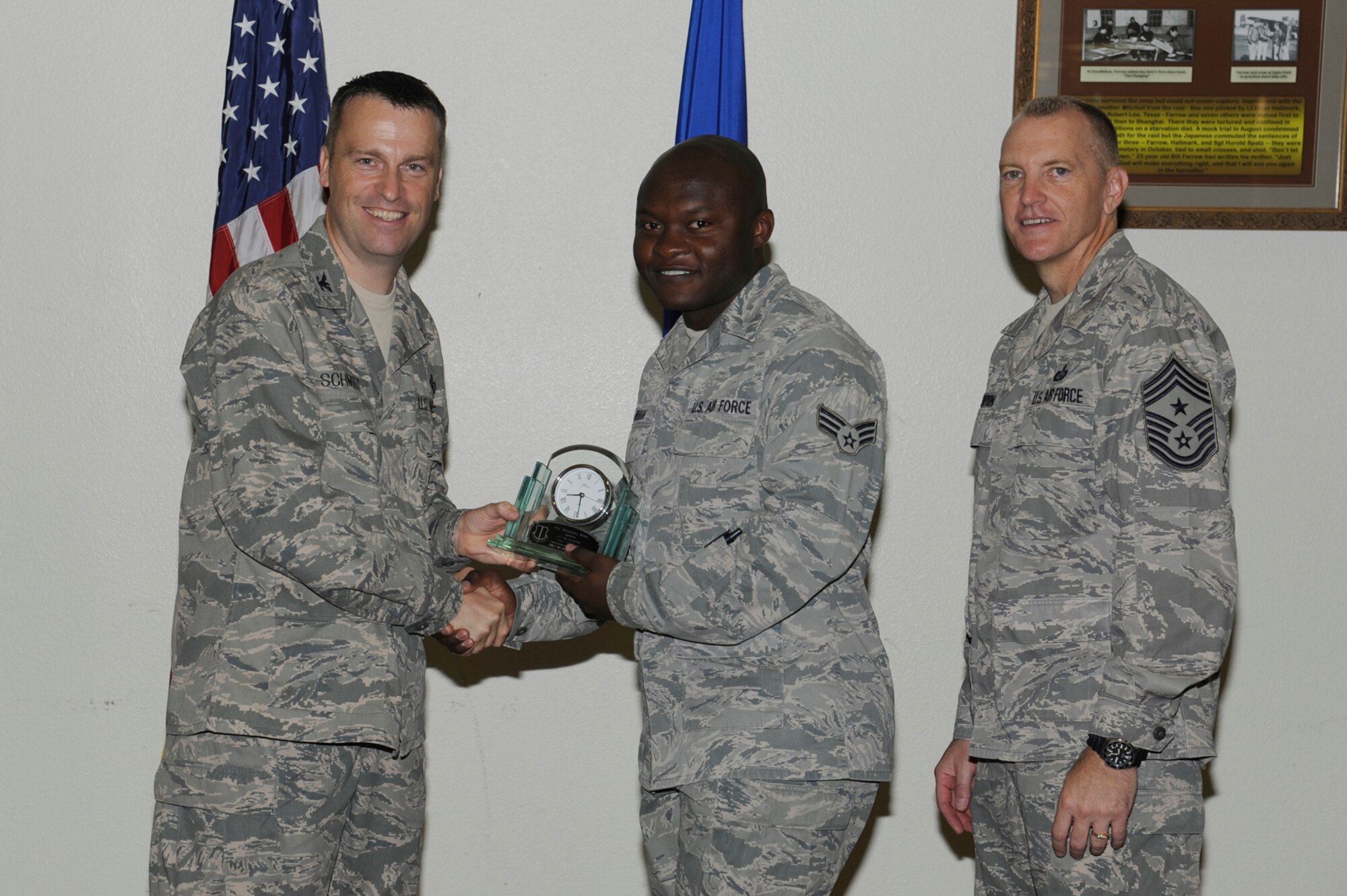 Col. Thomas Schmidt, 17th Training Wing Vice Commander, and Chief Master Sgt. Scott Lumpkin, 17th TRW Command Chief, present the 17th Training Wing Airman of the Quarter to Senior Airman Blaise Muluh, 17th Medical Operations Squadron, during the wing quarterly awards ceremony July 24. (U.S. Air Force photo by Staff Sgt. Austin Knox)
