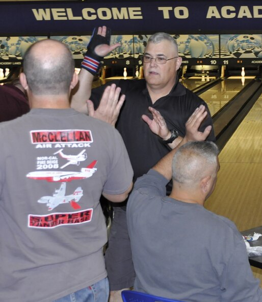 Tech. Sgt. Ray Schwab (back to bowling alley), 302nd Airlift Wing Maintenance Squadron, is congratulated by his teammates after picking up a spare during the 10th annual 302nd Airlift Wing bowling tournament April 14 at the U.S. Air Force Academy. Schwab and his team “The Maintenance Misfits” came in fifth place with 2,125 pins.  (U.S. Air Force photo/Tech. Sgt. Daniel Butterfield)