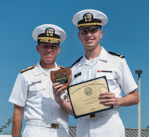 Ensign Paul Gale receives the Behrens award for Officer Class 1202 from Rear Adm. Richard Breckenridge, Submarine Group Two commander, during the Naval Nuclear Power Training Command graduation ceremony July 20, 2012, at Joint Base Charleston - Weapons Station, S.C. The Behrens award is given to the officer with the highest grade point average. (U.S. Air Force photo/Airman 1st Class Ashlee Galloway)