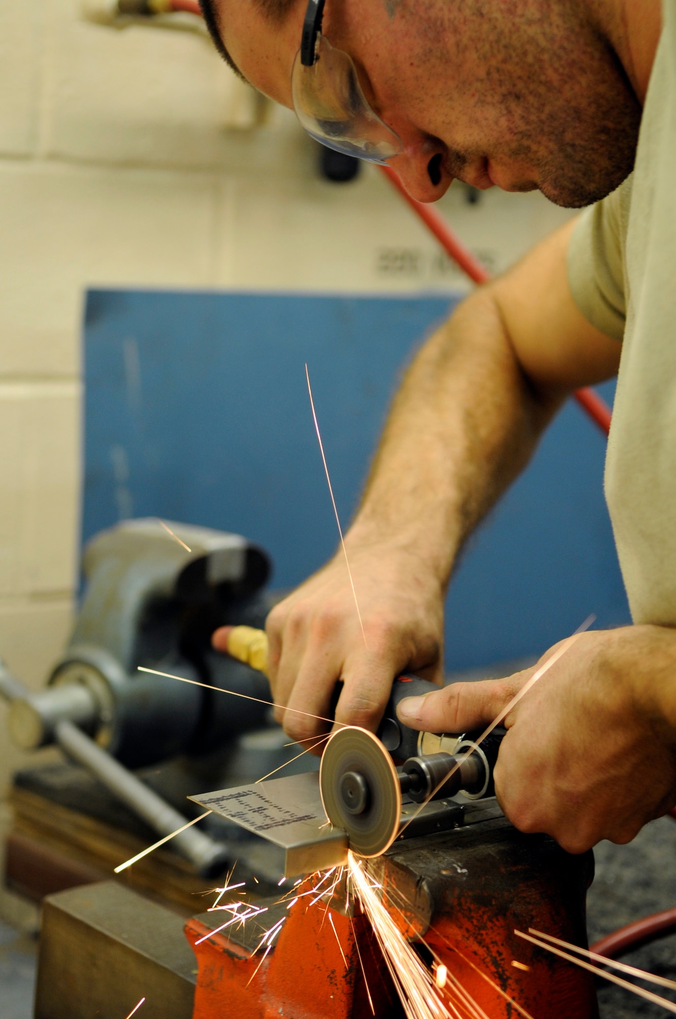 Airman 1st Class Andrew Mathews, 2nd Maintenance Squadron aircraft structural maintenance apprentice, uses a grinder to cut sheet metal on Barksdale Air Force Base, La., July 23. Mathews fabricated and manufactured an L-angle bracket from sheet metal to connect to the fire wall on the engine of a B-52H Stratofortress. (U.S. Air Force photo/Airman 1st Class Joseph A. Pagán Jr.)(RELEASED)