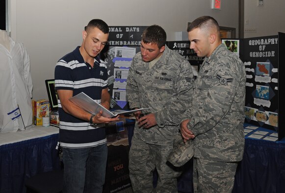 Airman 1st Class Brandon Boudreau, 2nd Contracting Squadron, explains to two Airmen what Days of Remembrance is during Multicultural Day on Barksdale Air Force Base, La., July 20. The Days of Remembrance is a national commemoration of the Holocaust and all of those who were affected by it. The eight day period is held to help educate others on the events so the Holocaust victims are never forgotten. (U.S. Air Force photo/Airman 1st Class Benjamin Gonsier)(RELEASED)