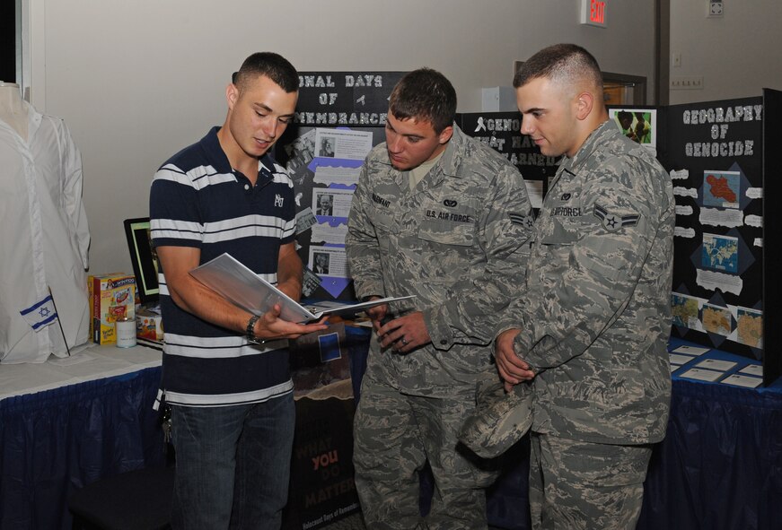 Airman 1st Class Brandon Boudreau, 2nd Contracting Squadron, explains to two Airmen what Days of Remembrance is during Multicultural Day on Barksdale Air Force Base, La., July 20. The Days of Remembrance is a national commemoration of the Holocaust and all of those who were affected by it. The eight day period is held to help educate others on the events so the Holocaust victims are never forgotten. (U.S. Air Force photo/Airman 1st Class Benjamin Gonsier)(RELEASED)