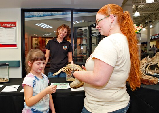 Misty Hailstone, a biologist with Edwards Environmental Management, lets six-year-old Breanna Sanford pet a Gopher snake during a wildlife safety demonstration hosted by EM and the 31st Test and Evaluation July 19 at the Base Exchange. (U.S. Air Force photo by Jet Fabara)