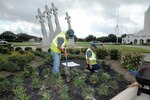 Hector Montoya (left), and Hector Perez, Fairways Landscaping service professionals, plant flowers around the Missing Man Monument on Joint Base San Antonio-Randolph, Texas, July 24. (U.S. Air Force photo by Rich McFadden) 