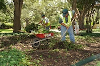 Hector Montoya (left), and Hector Perez, Fairways Landscaping service professionals, clear ground clutter around the Clark House on Joint Base San Antonio-Randolph, Texas, July 24. (U.S. Air Force photo by Rich McFadden) 