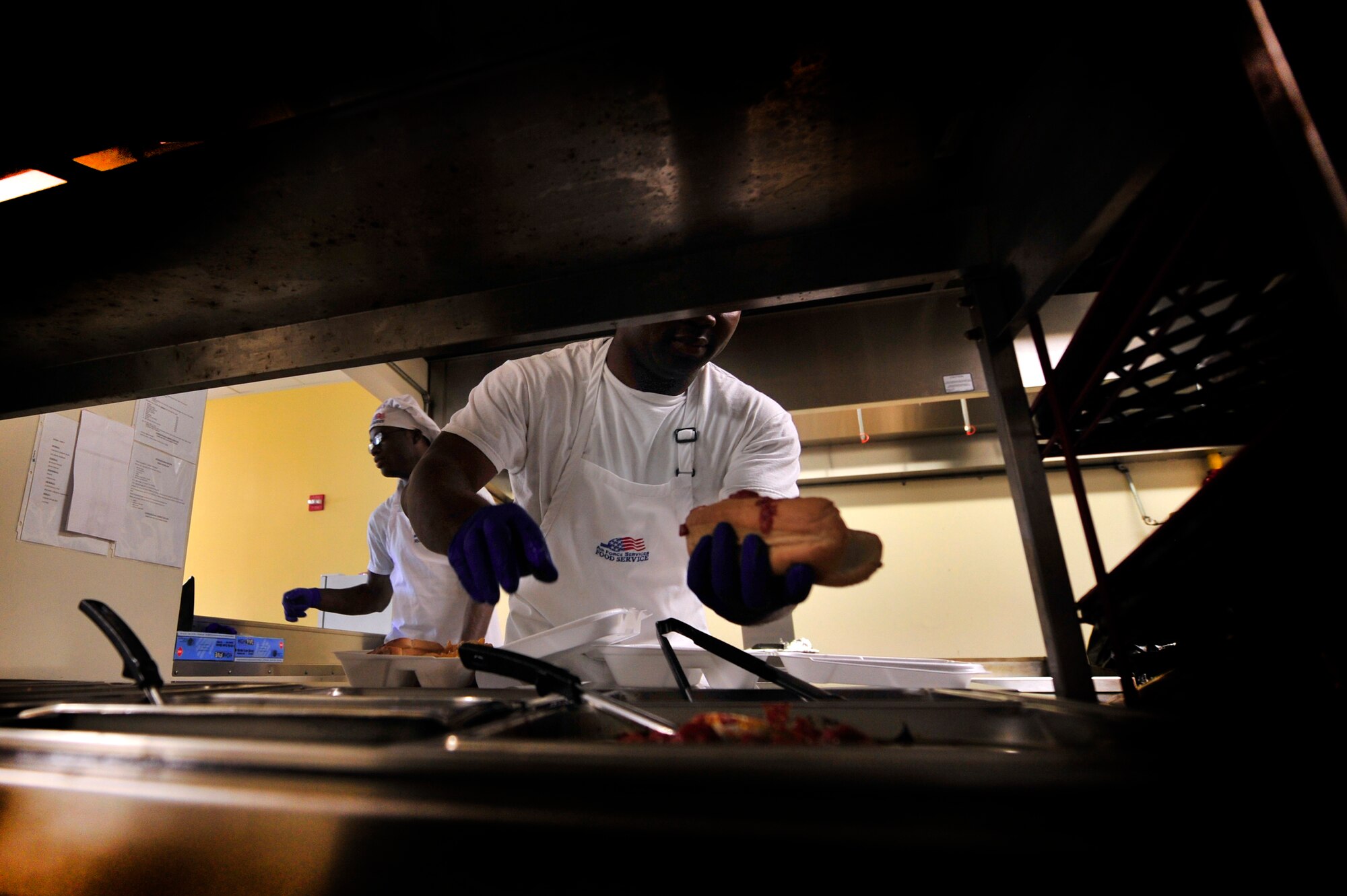 U.S. Air Force Senior Airman John Grant (left) and Airman 1st Class Wendell Walker, both 20th Force Support Squadron food service specialists, prepare chow for Airmen during a lunch hour rush at the Afterburner Grill, July 20, 2012, Shaw Air Force Base, S.C.  The Afterburner Grill is Shaw’s second dining facility which offers personnel working on the flightline a more accessible facility to get lunch and dinner while continuing to support Shaw’s flying mission. (U.S. Air Force photo by Senior Airman Kenny Holston/Released)