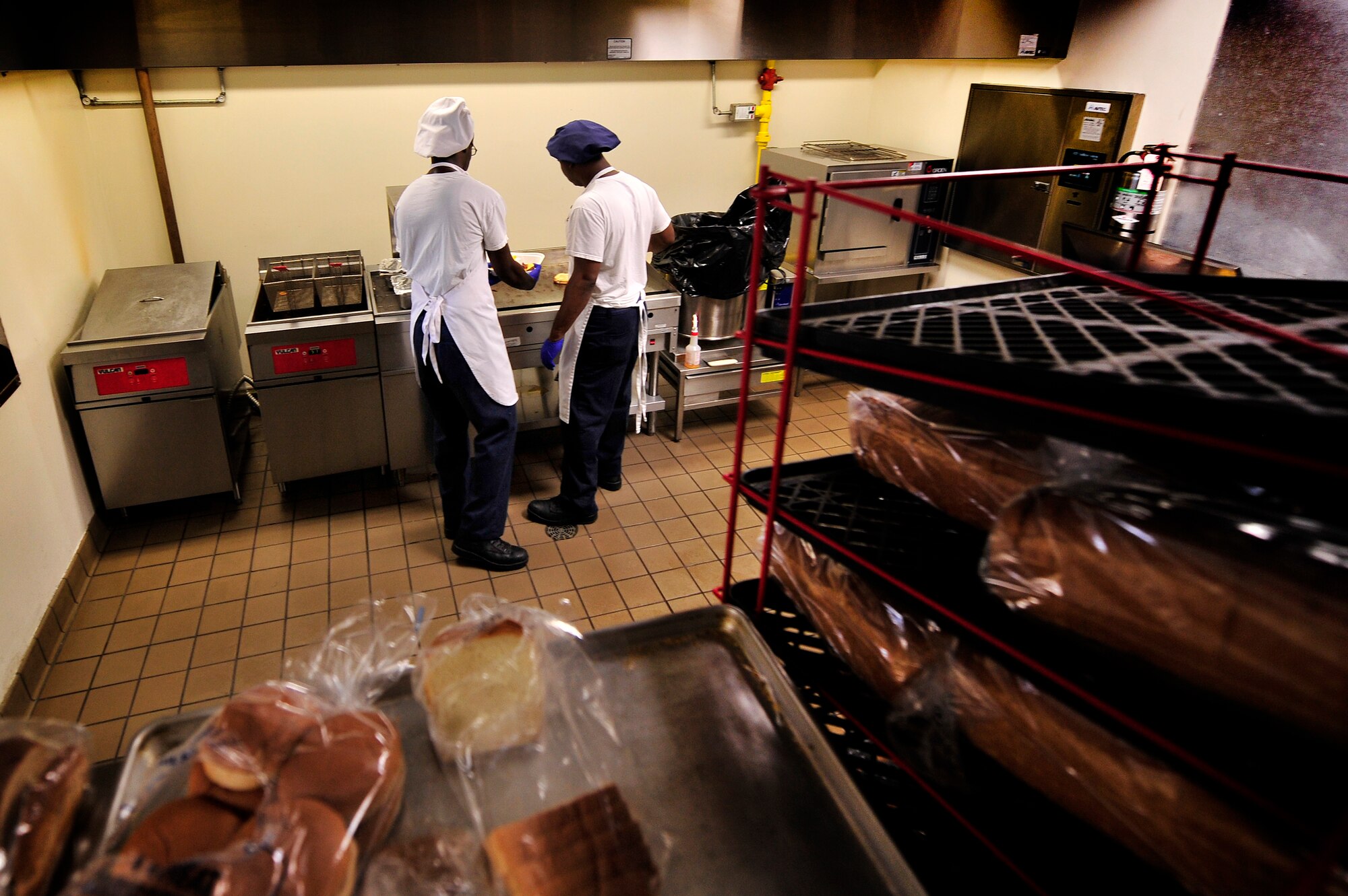 U.S. Air Force Senior Airman John Grant (left) and Airman 1st Class Wendell Walker, both 20th Force Support Squadron food service specialists, prepare lunch at the Afterburner Grill, July 20, 2012, Shaw Air Force Base, S.C. The Afterburner Grill is Shaw’s second dining facility which offers personnel working on the flightline a more accessible facility to get lunch and dinner while continuing to support Shaw’s flying mission. (U.S. Air Force photo by Senior Airman Kenny Holston/Released)