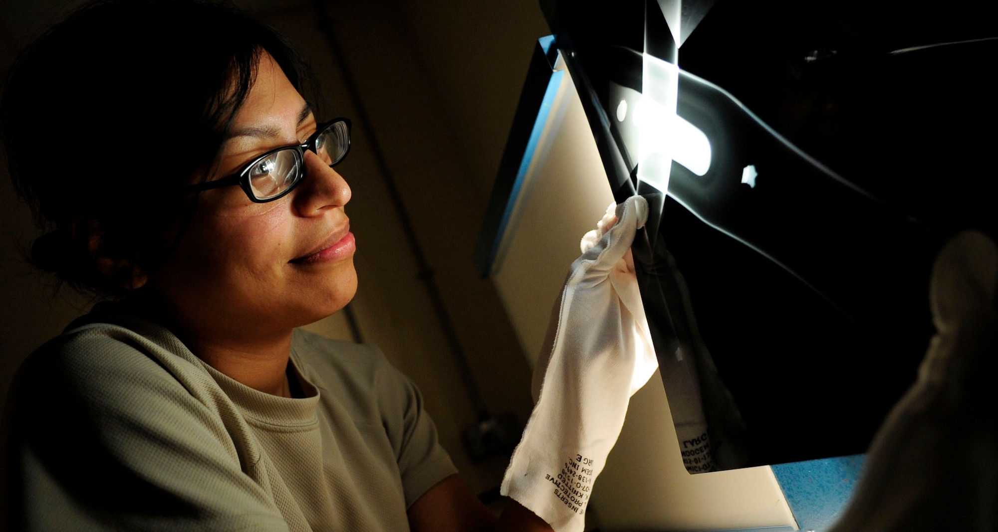 RAF MILDENHALL, England -- Senior Airman Sarah Hayes, 100th Maintenance Squadron Non-Destructive Inspection journeyman, examines X-ray films of a C-130 Hercules tube attach fitting at RAF Mildenhall July 18, 2012. X-rays are used primarily to detect cracks that may not otherwise be detected by the naked eye. (U.S. Air Force photo/Senior Airman Ethan Morgan)