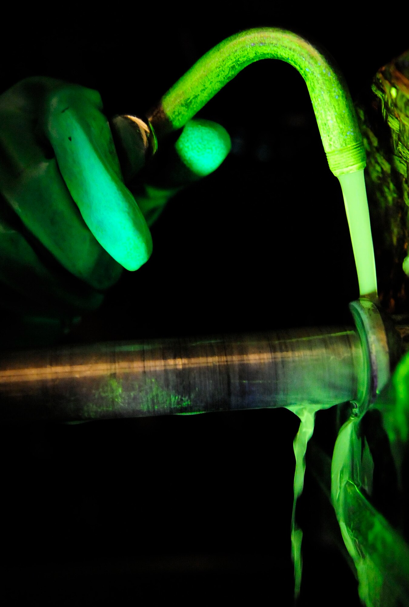 RAF MILDENHALL, England – Senior Airman Sarah Hayes, 100th Maintenance Squadron Non-Destructive Inspection journeyman, sprays a fluorescent magnetic bath on a C-130 engine mount bolt during a magnetic particle inspection at RAF Mildenhall July 18, 2012. The C-130 Hercules engine mount bolt is sprayed under a black light and magnetized so that any cracks can be identified. (U.S. Air Force photo/Senior Airman Ethan Morgan)