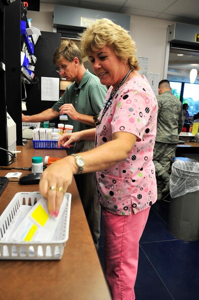 Marie Dallaire, 20th Medical Group pharmacy technician (front)  and John Barnett, 20th Medical Group pharmacist (back), check prescriptions at Shaw Air Force Base, S.C, July 19, 2012.  The pharmacy provides medication for over 31,000 beneficiaries.(U.S. Air Force photo by Airman Nicole Sikorski/Released) 