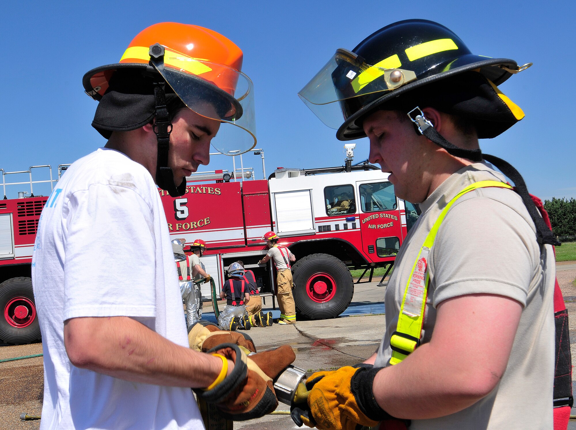 ROYAL AIR FORCE LAKENHEATH, England - Nicholas Foley, 2011 Boys & Girls Clubs of America National Youth of the Year (left), assists Airman 1st Class Ryan Muise, 48th Civil Engineer Squadron firefighter, in connecting the fire hose after a mock aircraft fire training exercise July 23, 2012. Foley's visit was part of the Headquarters United States Armed Forces in Europe Summer Leadership Assistant Program. (U.S. Air Force photo by Senior Airman Tiffany Deuel)