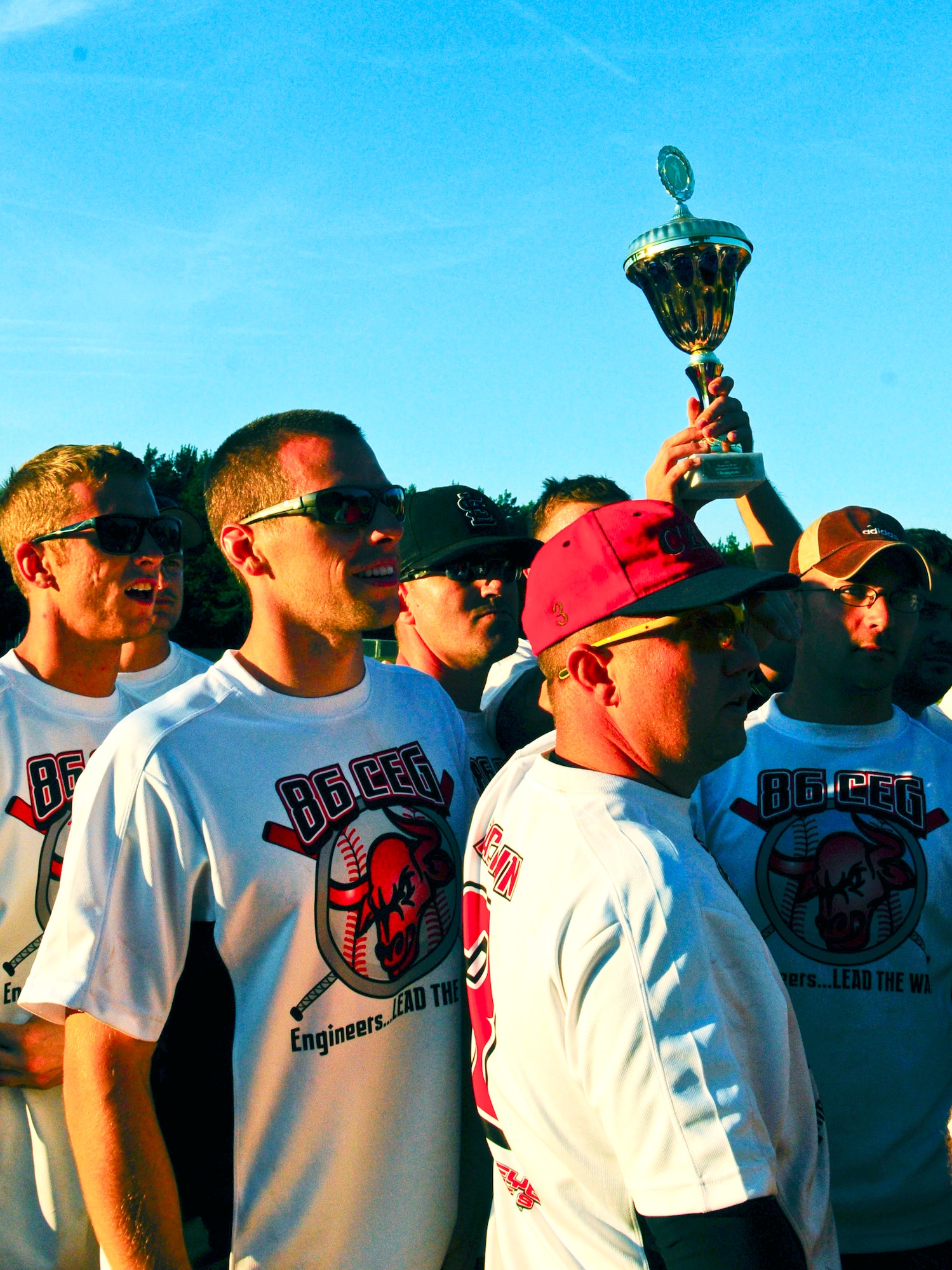 The 86th Civil Engineer Group team turns to their fans and holds up their new trophy after winning the Ramstein Intramural Softball Tournament at Kapaun Air Station, Germany, July 22, 2012. The tournament was hosted by the Ramstein Rams softball team and brought in teams from all over Europe, including Belgium and Bamberg. (U.S. Air Force photo/Airman 1st Class Hailey Haux)