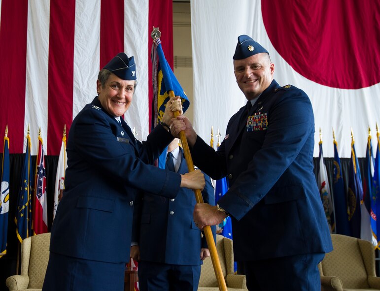 YOKOTA AIR BASE, Japan -- Col. Darlene Sanders, 374th Maintenance Group commander, left, hands the 374th Maintenance Squadron guidon to Maj. Thomas Fiordelisi, 374th MOS incoming commander, during the 374th MOS change of command ceremony at Yokota Air Base, Japan, July 24, 2012.  The passing of the guidon to the new commander signifies the start of the new command. (U.S. Air Force photo by Staff Sgt. Chad C. Strohmeyer)