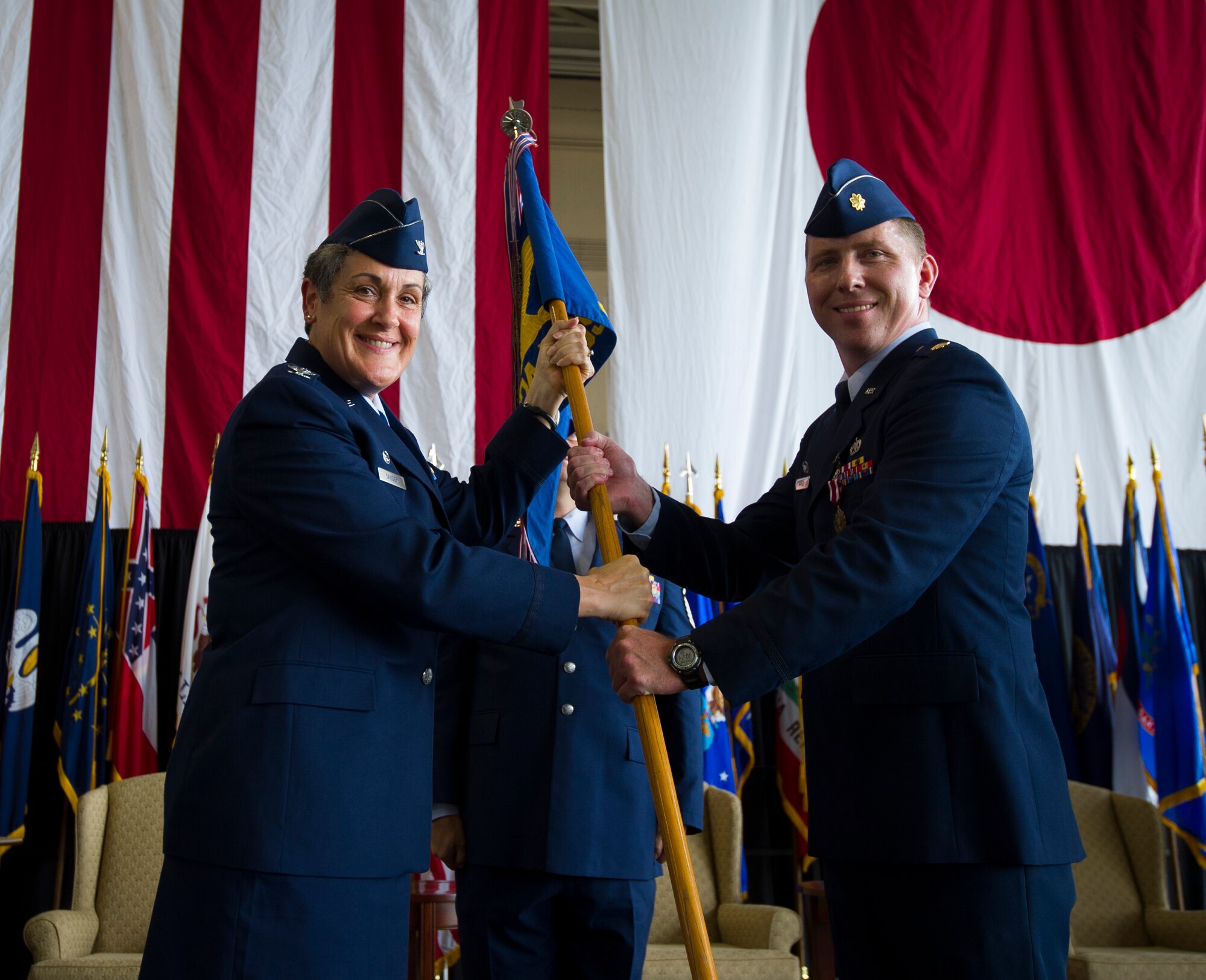 YOKOTA AIR BASE, Japan -- Maj. James Hayes, 374th Maintenance Operations Squadron outgoing commander, right, hands the squadron guidon to Col. Darlene Sanders, 374th Maintenance Group commander, during the 374th MOS change of command ceremony at Yokota Air Base, Japan, July 24, 2012.  The guidon is a tradition dating back to Roman times, where military units would carry a banner with their emblem into battle. (U.S. Air Force photo by Staff Sgt. Chad C. Strohmeyer)