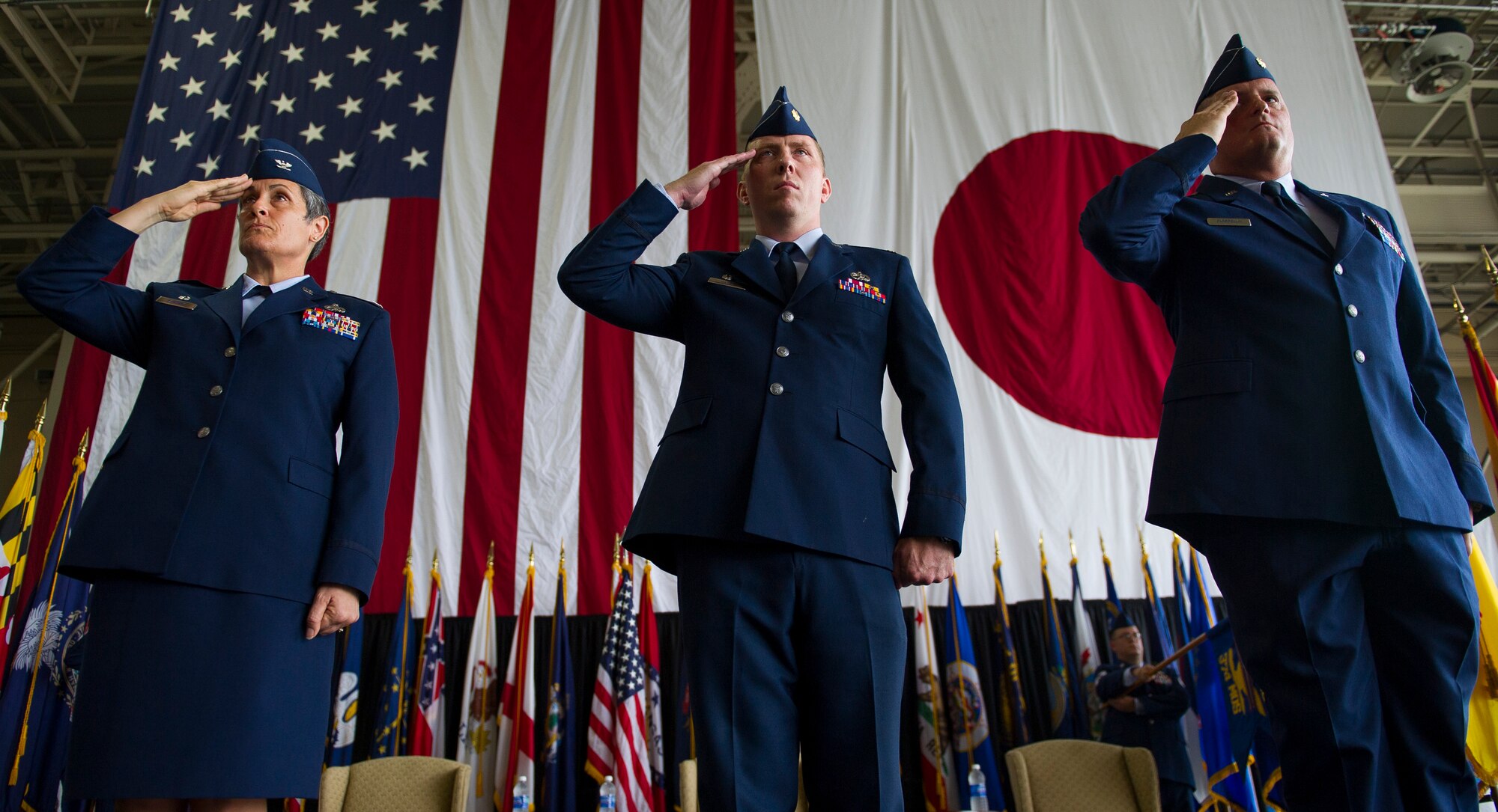YOKOTA AIR BASE, Japan – From the left, Col. Darlene Sanders, 374th Maintenance Group commander, Maj. James Hayes, 374th Maintenance Operations Squadron outgoing commander, and Maj. Thomas Fiordelisi, 374th MOS incoming commander, salute during the Japanese and American National Anthems during the 374th MOS change of command ceremony at Yokota Air Base, Japan, July 24, 2012.  (U.S. Air Force photo by Staff Sgt. Chad C. Strohmeyer)