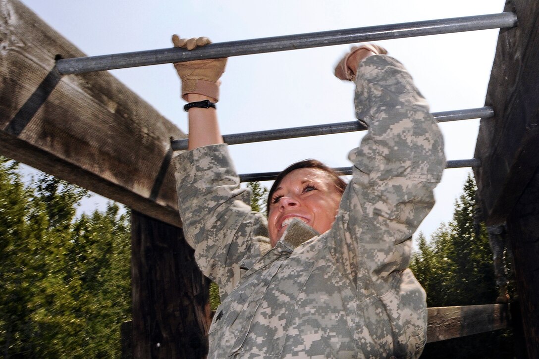 Army Sgt. Leslie Greenfield tackles the horizontal bars during joint operations training with soldiers assigned to the 95th Chemical Company, 2nd Engineer Brigade, at Landing Zone Ranger on Joint Base Elmendorf-Richardson, Alaska, July 19, 2012. Greenfield is assigned to the 95th Civil Support Team, California National Guard.