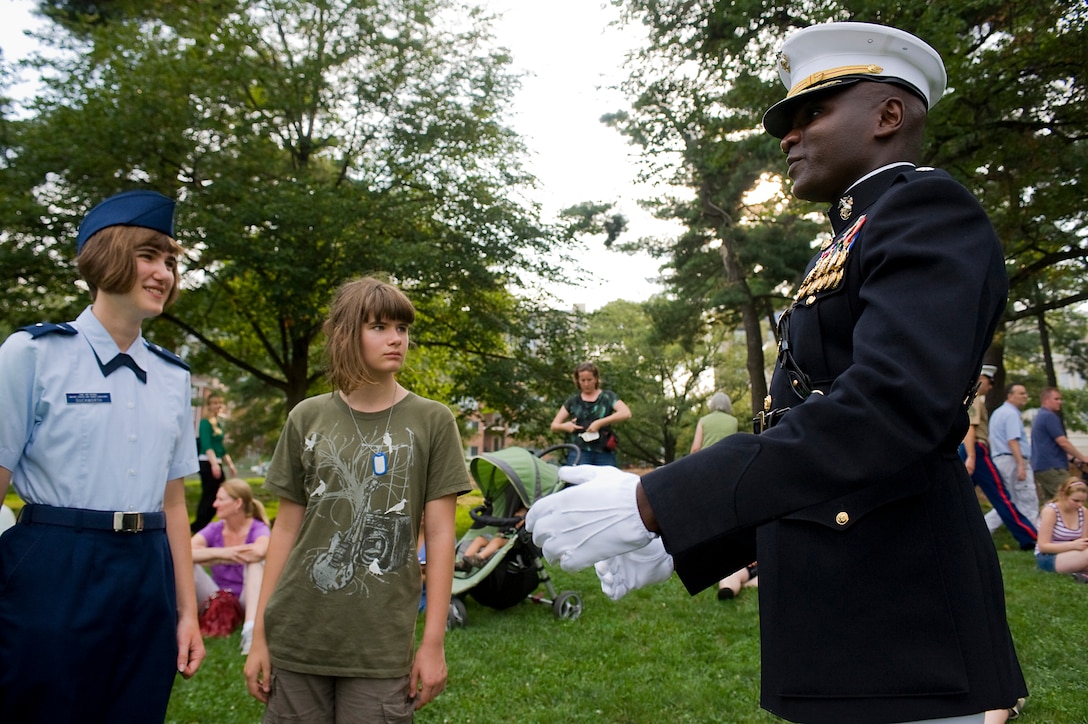 Lt. Col. Marvin Reed, Marine Corps Institute company commander, speaks with a young spectator at a Tuesday Sunset Parade at the Marine Corps War Memorial in Arlington, Va., July 24.