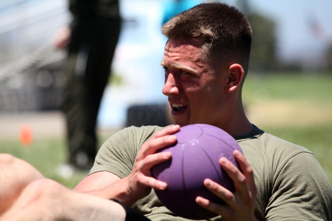 Cpl. Sean Flynn with 1st Battalion, 11th Marines, Marine Corps Base Camp Pendleton, performs "Russian Twists" with a medacine ball during the Combat Conditioning Training Course at the Paige Field House on Camp Pendleton, July 24. This two-day course included classes on nutrition, injury prevention, power lifting and TRX exercises.