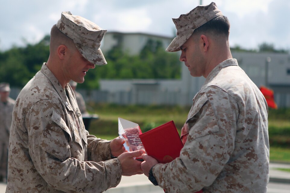 Gunnery Sgt. John S. Mosser, right, is presented the Gunnery Sergeant John A. Basilone Award for Courage and Commitment by Lt. Col. Travis L. Homiak during a ceremony at Camp Schwab May 3. Mosser is a platoon sergeant with 3rd Reconnaissance Battalion, 3rd Marine Division, III Marine Expeditionary Force. Homiak is the commanding officer of 3rd Recon. Bn.