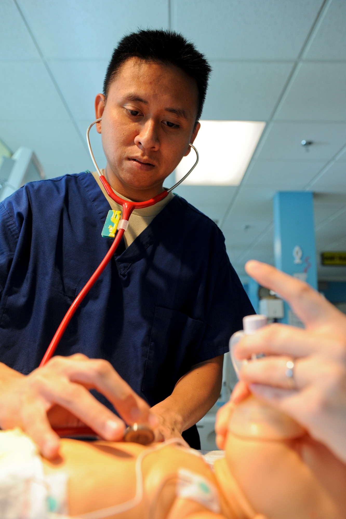U.S. Air Force Airman 1st Class Rudyar Burgos, 18th Medical Group medical technician, simulates listening for a heart beat during training on Camp Lester Naval Hospital, July 20, 2012. The hospital's neonatal intensive care unit is the second largest in the Air Force and is also able to get a crew in the air in three hours to help tiny patients in need. (U.S. Air Force photo/Airman 1st Class Brooke P. Beers)