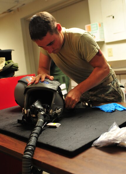 U.S. Senior Airman Scott Waclawk, 23d Operations Support Squadron aircrew flight equipment technician, fixes a visor for U.S. Air Force Maj. Bart Ward, A-10C Thunderbolt II pilot, before heading out to the flightline during the Red Flag 12-4 exercise at Nellis AFB, Nev., July 23, 2012. Ward noticed his visor was coming off during a pre-flight equipment inspection. (U.S. Air Force photo by Staff Sgt. Stephanie Mancha/Released)