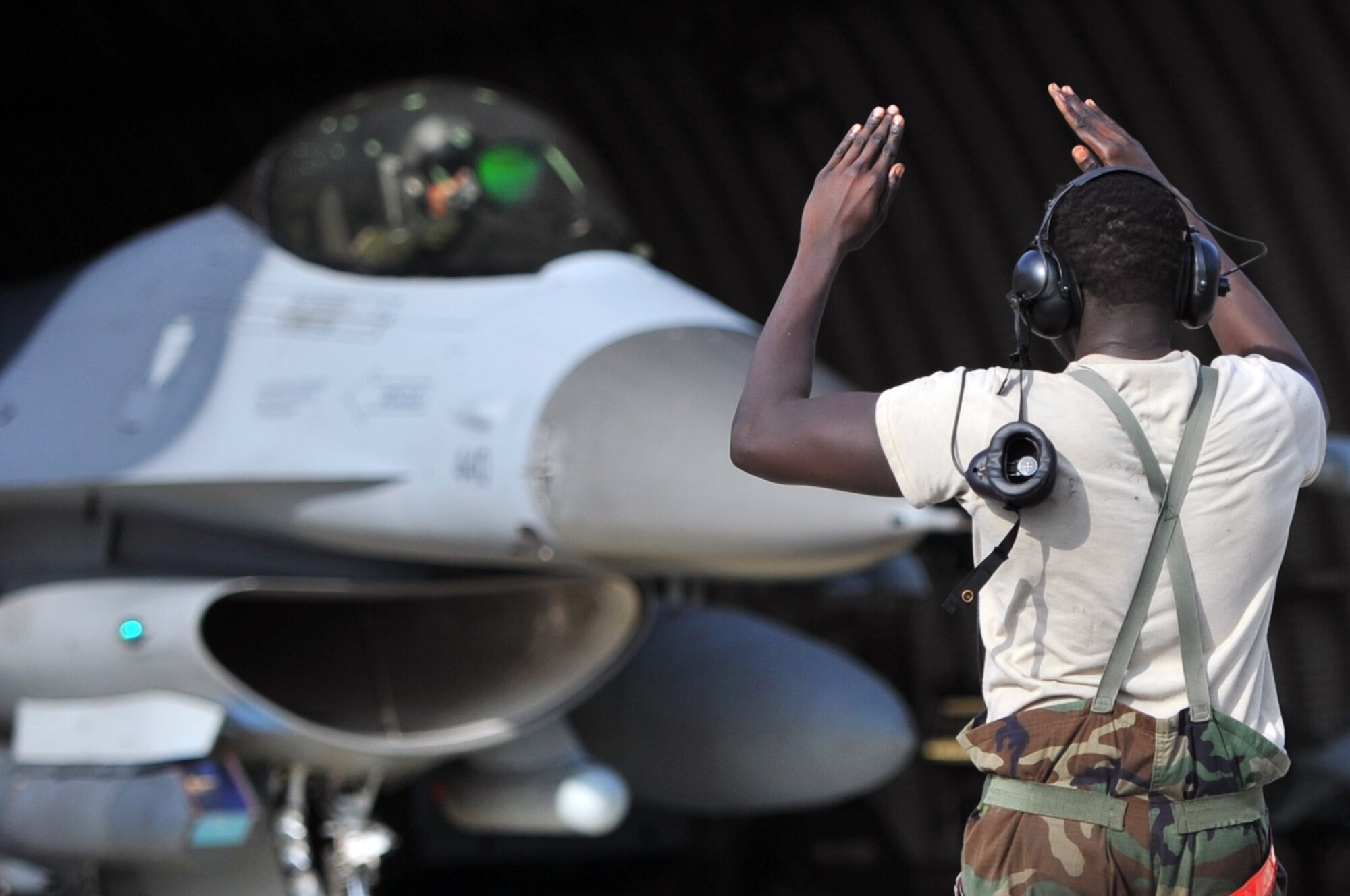 Senior Airman Tethloach Wuol, 36th Fighter Squadron crew chief, guides an F-16 Fighting Falcon out of a hardened aircraft shelter at Osan Air Base, Republic of Korea, July 25, 2012. Osan Airmen are in the fourth simulated wartime contingency exercise executed in 2012 that test the base’s ability to defend and execute the mission in a heightened state of readiness. Osan’s Airmen provide combat ready forces for close air support, air strike control, counter air, interdiction, theater airlift, and communications in the defense of the Republic of Korea. (U.S. Air Force photo/Staff Sgt. Craig Cisek) 