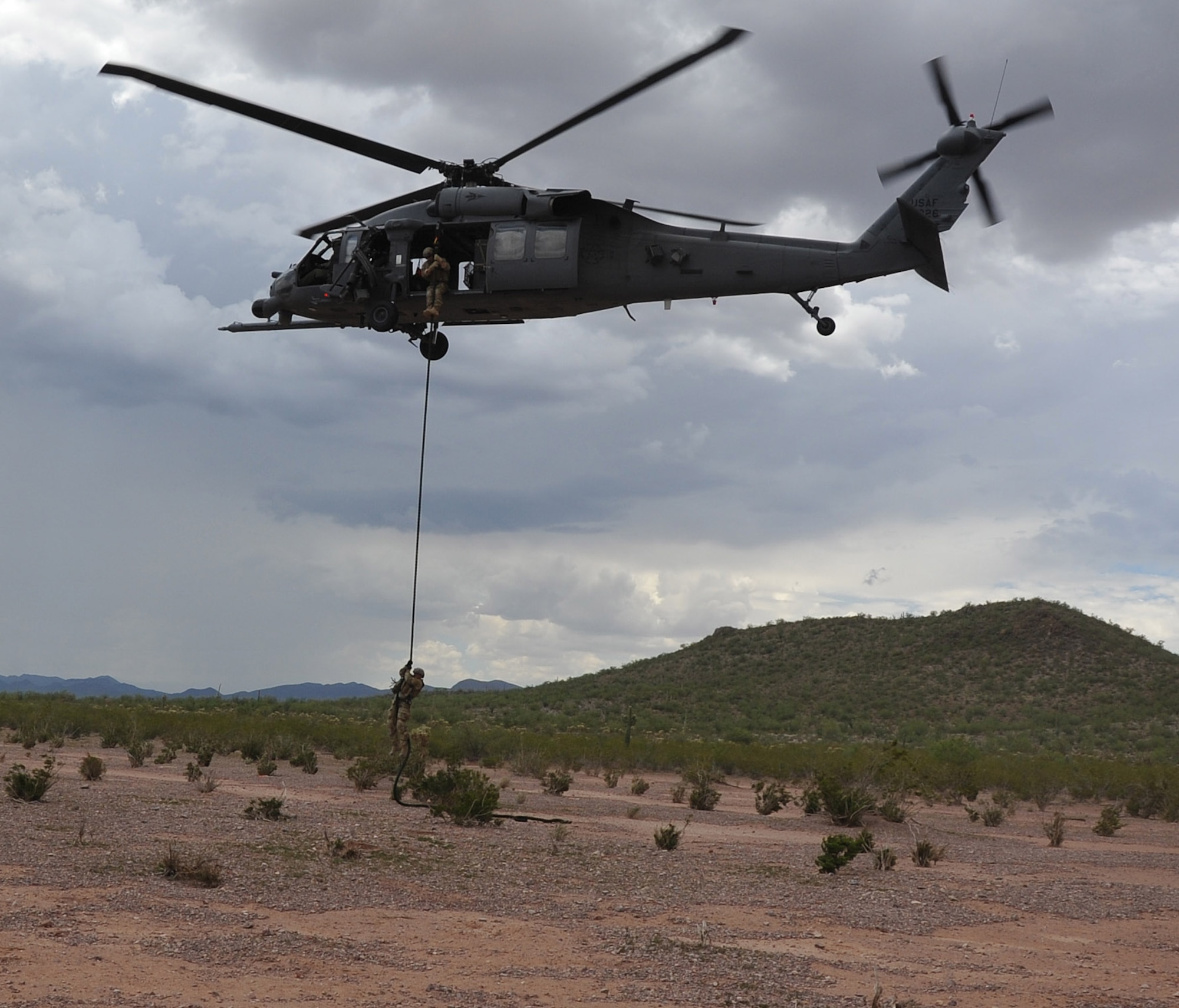 Two pararescuemen with the 306th Rescue Squadron fast rope from a HH-60 Pave Hawk helicopter assigned to the 305th Rescue Squadron.  Both rescue squadrons are assigned to the 943rd Rescue Group located at Davis-Monthan Air Force Base Ariz. The 943rd RQG trains personnel with equipment to preform day or night combat search and rescue missions, and the group also provides humanitarian and disaster relief operation support. (U.S. Air Force photo/ Master Sgt. Luke Johnson) 
